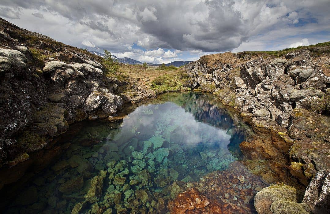 Clear glacial water fills the Silfra fissure at Þingvellir National Park in Iceland.