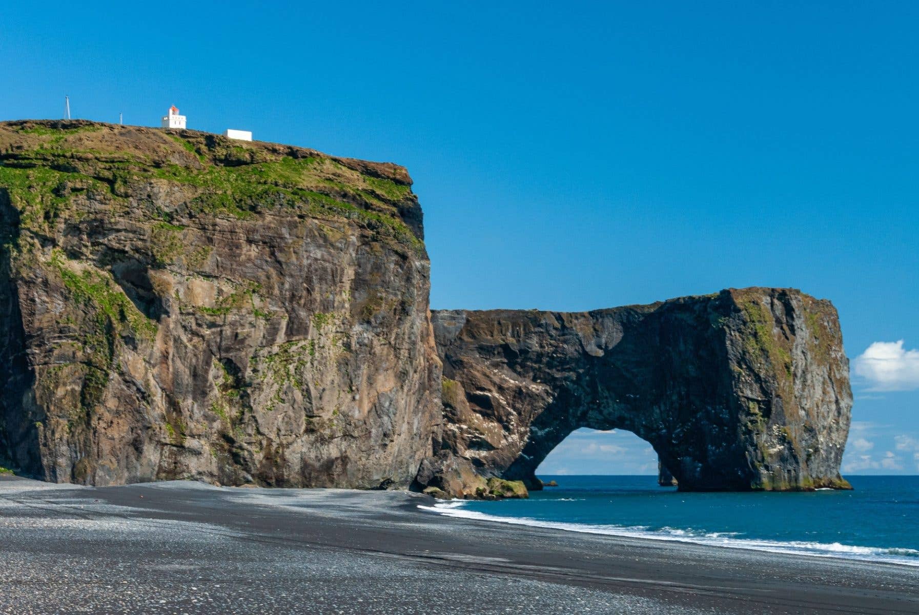 The great sea arch of Dyrhólaey juts into the ocean on the south coast of Iceland.