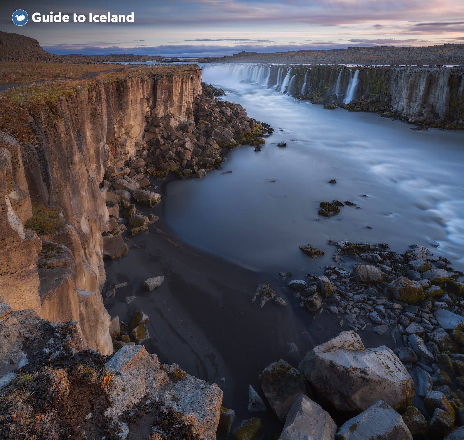 The wide Selfoss waterfall pours over a rocky ledge on the Jökulsá á Fjöllum river in North Iceland.