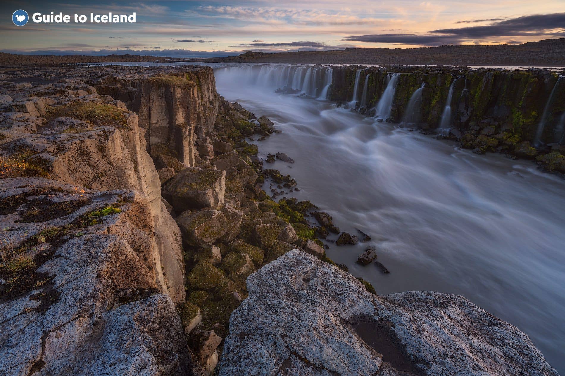 Water spills across the broad rim of Selfoss waterfall in Vatnajökull National Park, North Iceland.