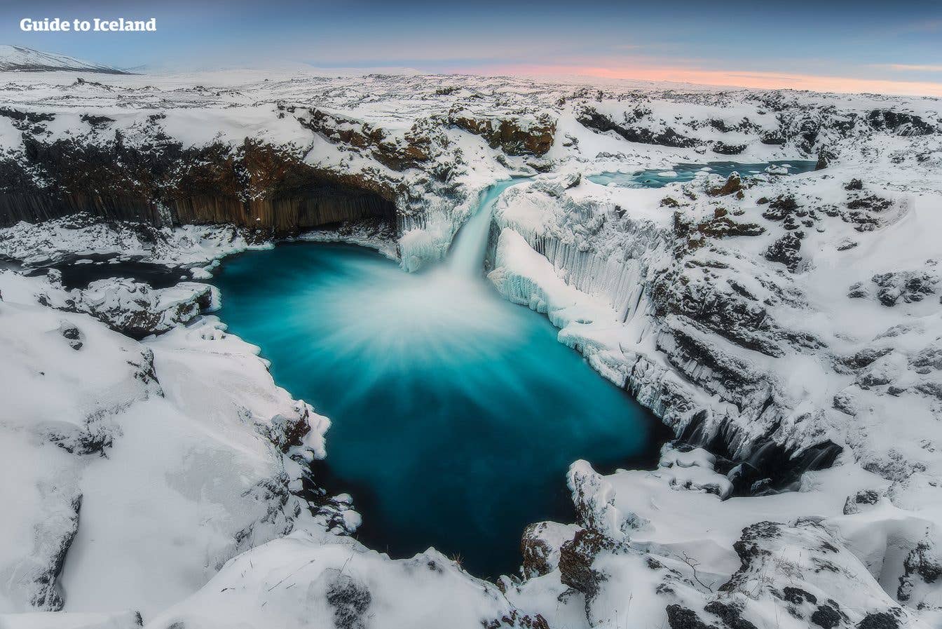 The Aldeyjarfoss waterfall drops between tall basalt columns in the highlands of North Iceland.