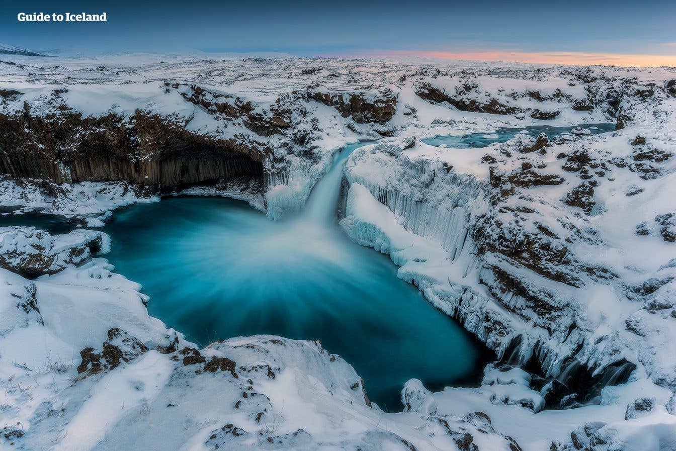 Snow lines the basalt cliffs around the Aldeyjarfoss waterfall in the highlands of North Iceland.