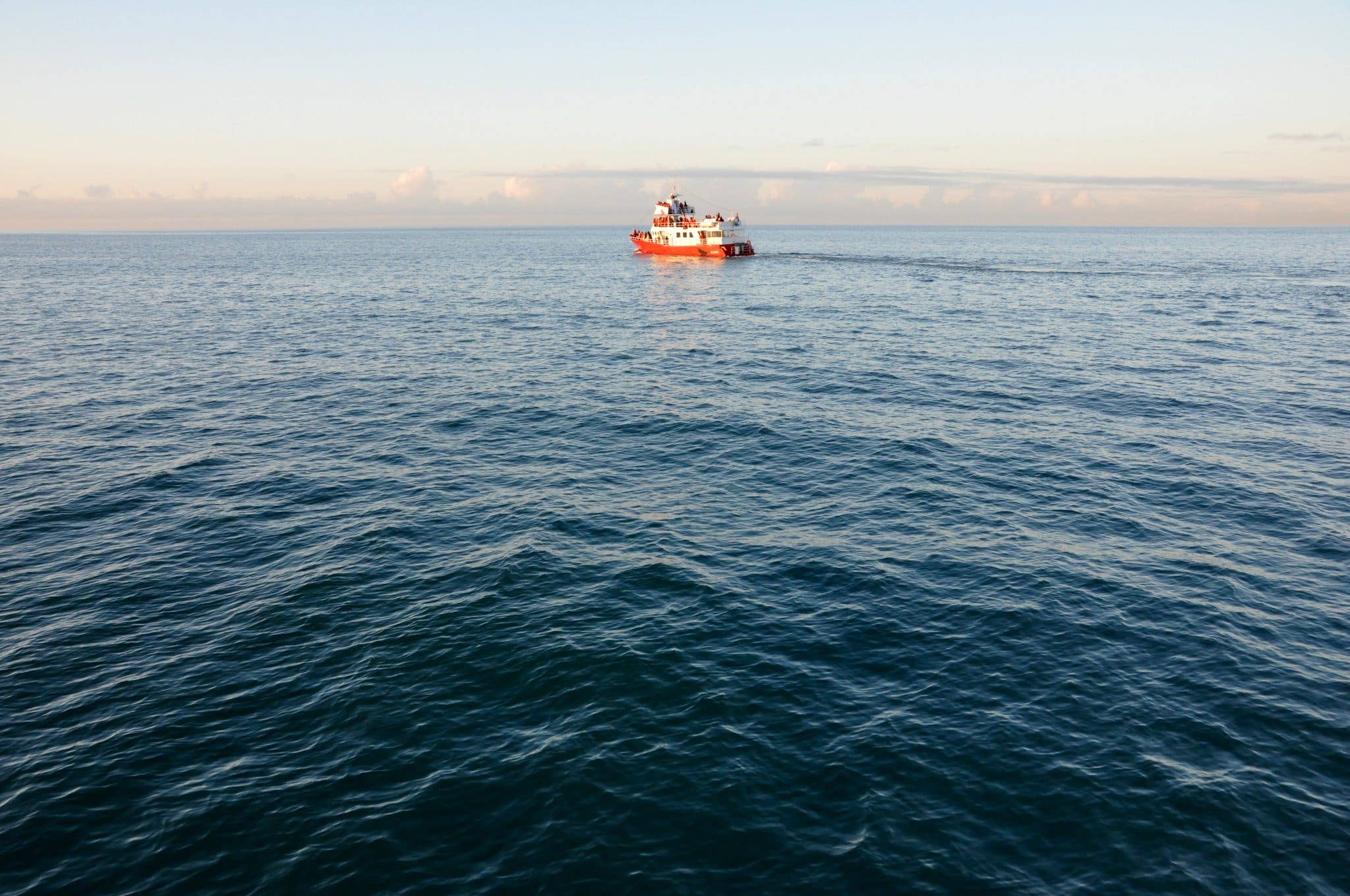 A whale-watching boat sails the calm waters of Skjálfandi bay near Húsavík in North Iceland.