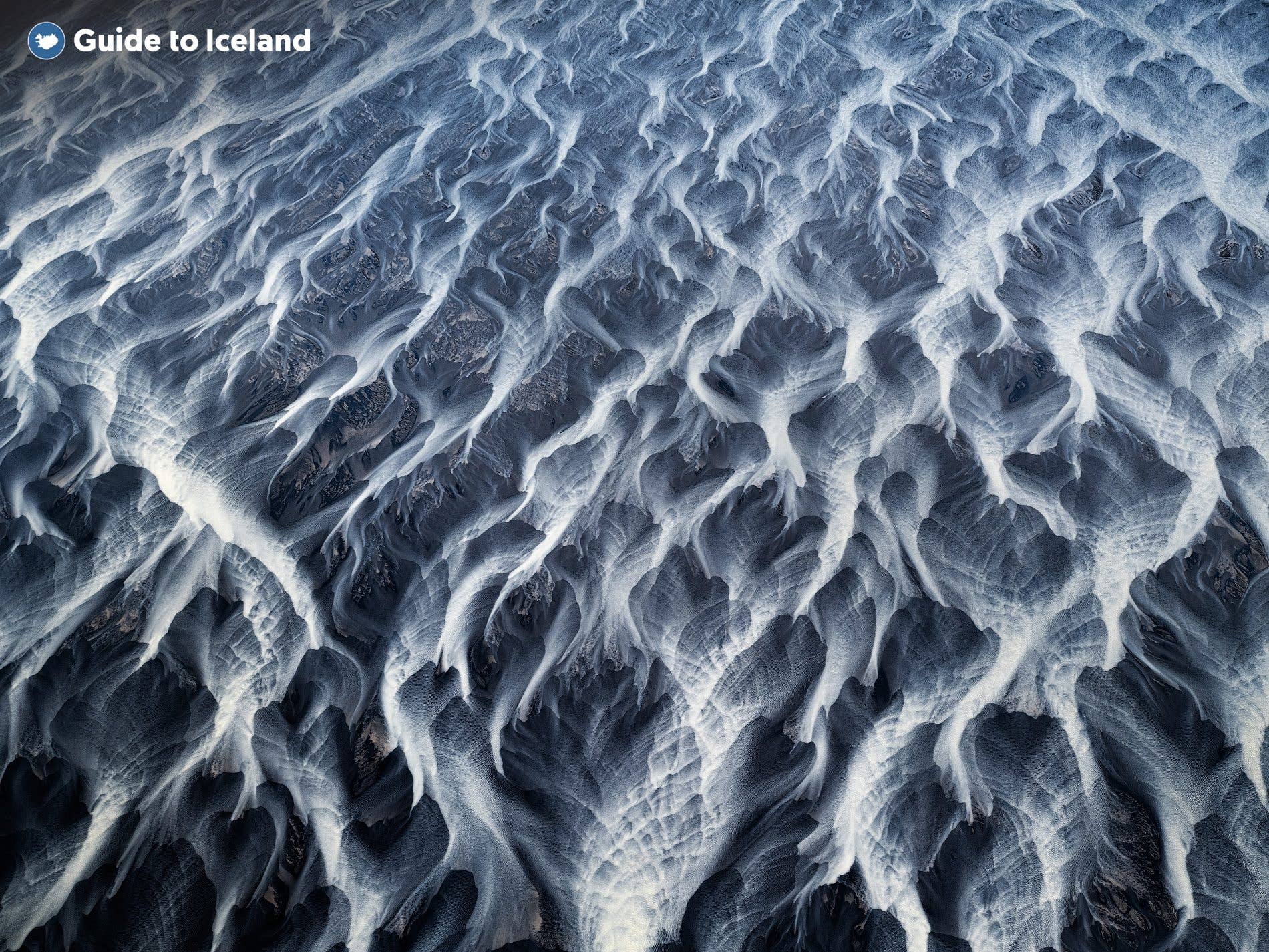 A glacial river braids across the volcanic sands of the Icelandic highlands.