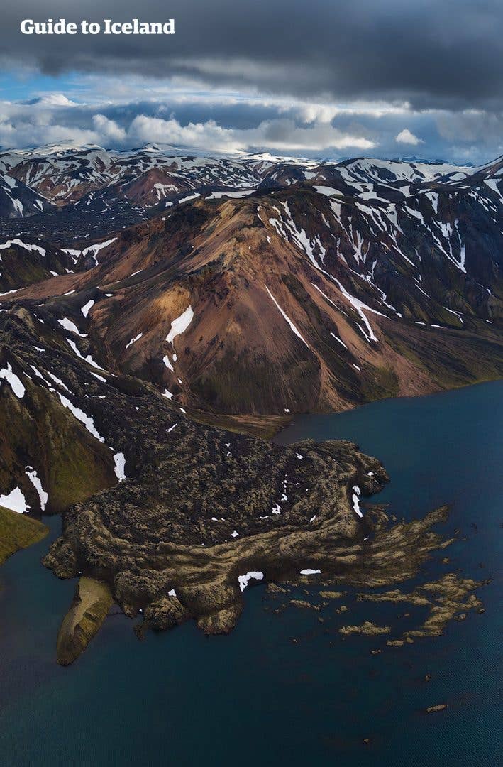 A dark lava peninsula reaches into a highland lake near Landmannalaugar in Iceland.