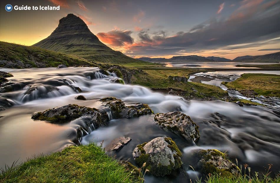 A stream flows past Kirkjufell mountain at sunset on the Snæfellsnes Peninsula in West Iceland.
