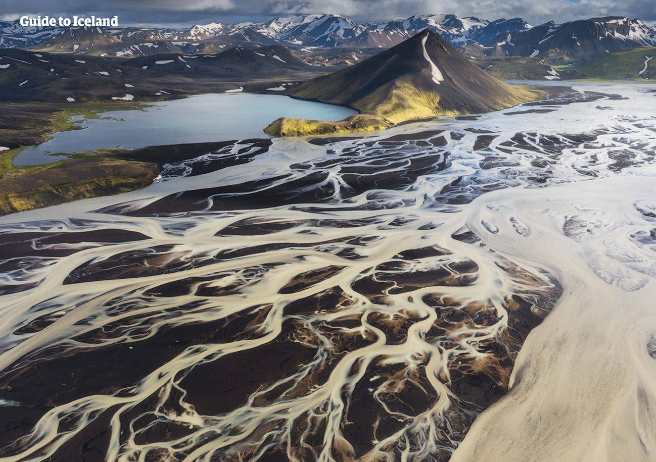 Glacial rivers braid around the mossy Mælifell cone in the highlands of South Iceland.