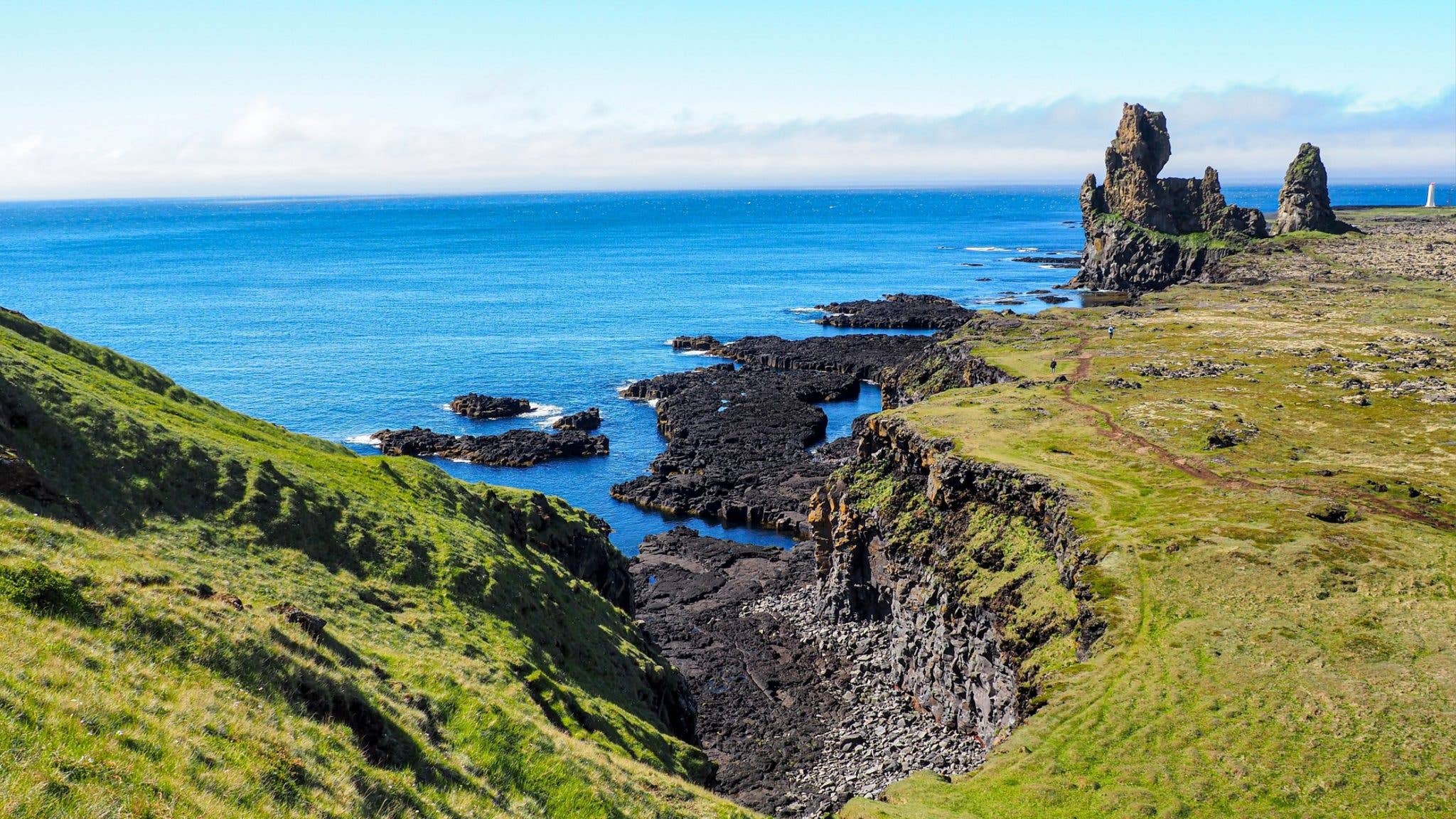 The Lóndrangar basalt sea cliffs rise above the ocean on the Snæfellsnes Peninsula, Iceland.