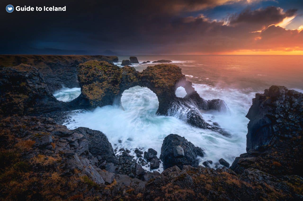 The rocky coast glows at sunset near Hellnar on the Snæfellsnes Peninsula in West Iceland.