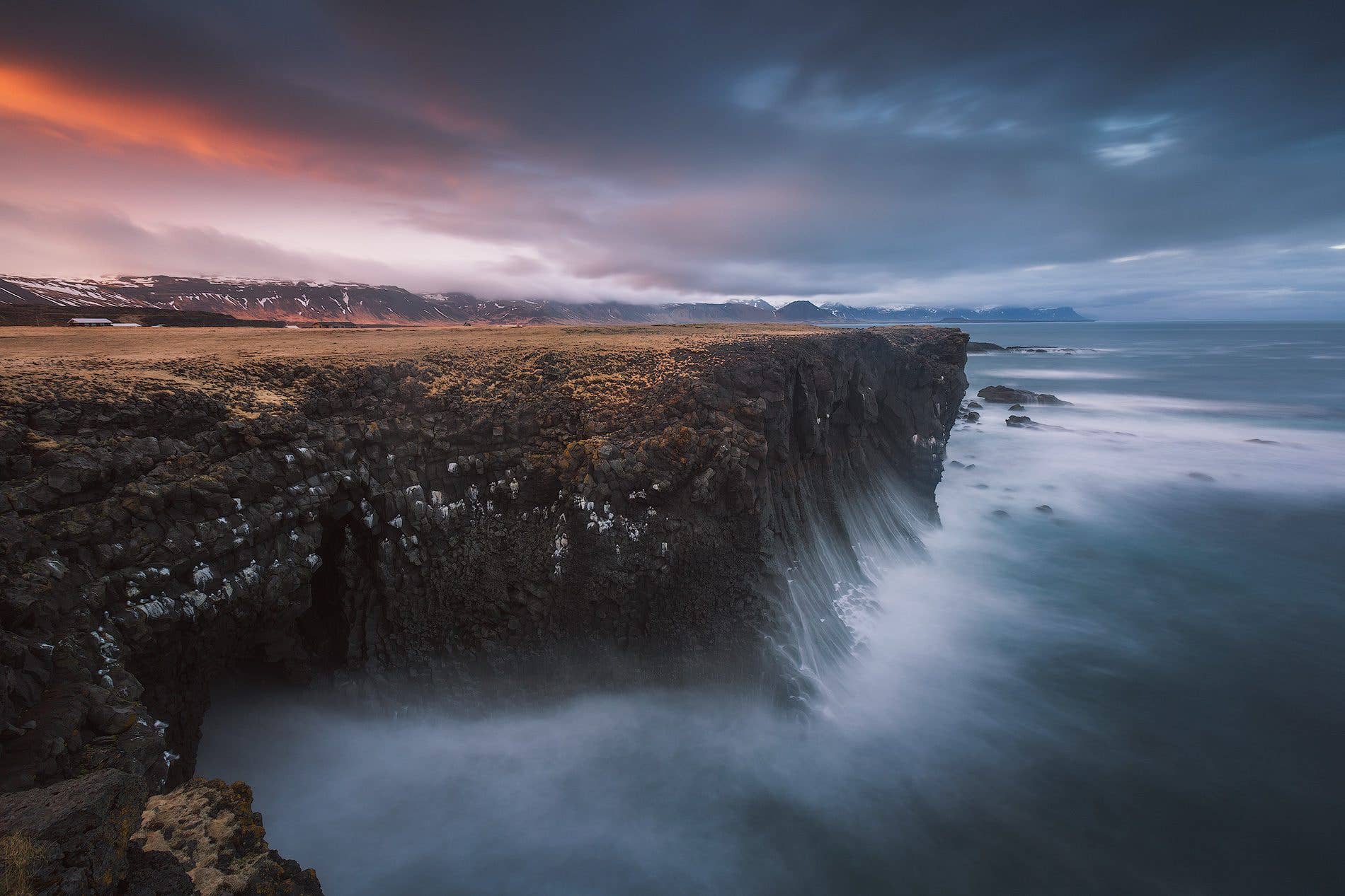 Waves break against the dark cliffs of the rugged Snæfellsnes coast in West Iceland.