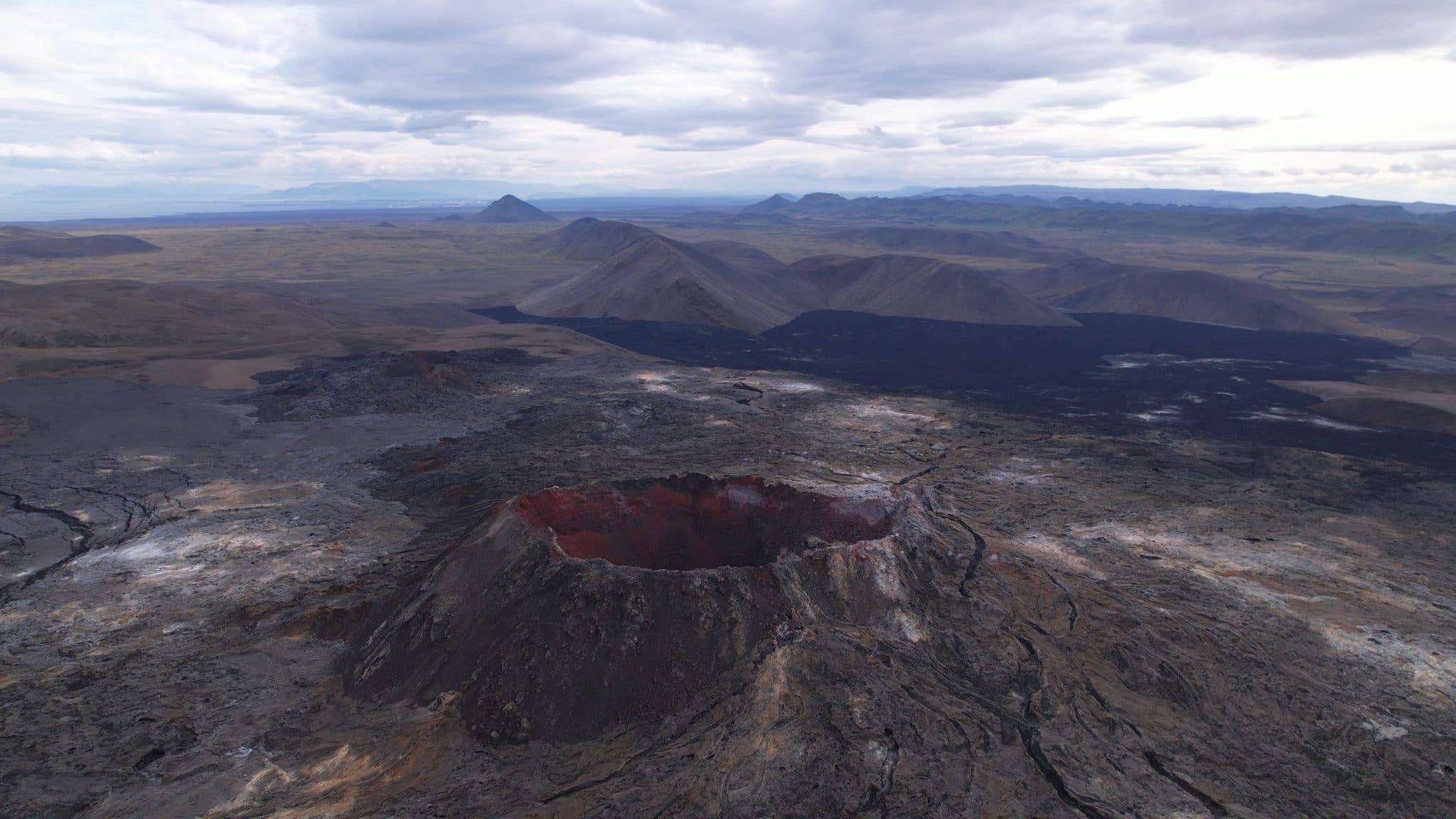 Cooled black lava fills the crater of the Fagradalsfjall volcano on the Reykjanes Peninsula, Iceland.