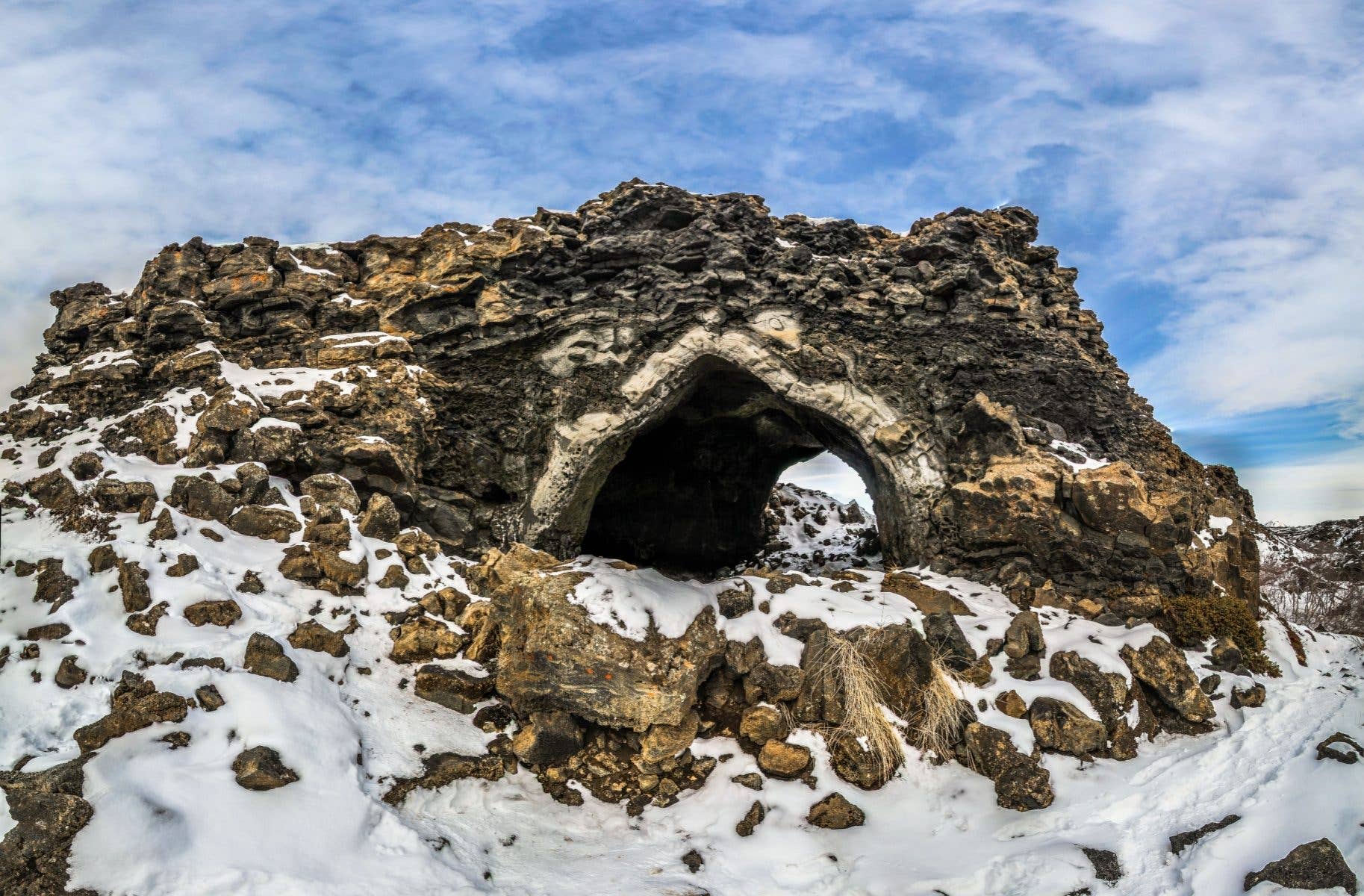 A natural rock arch stands among the lava formations of Dimmuborgir near Lake Mývatn in North Iceland.