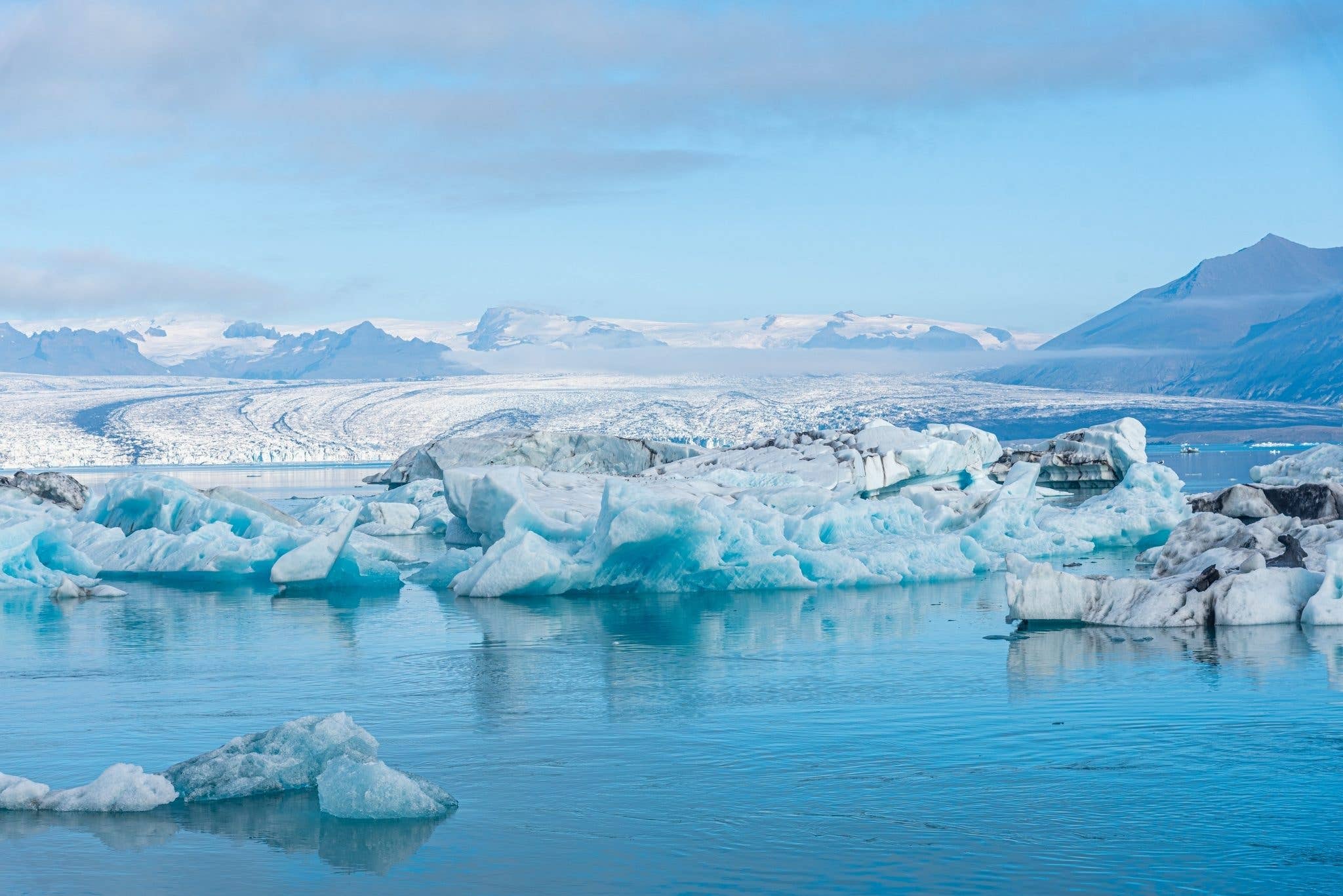 Icebergs float on the calm water of the Jökulsárlón glacier lagoon in Southeast Iceland.
