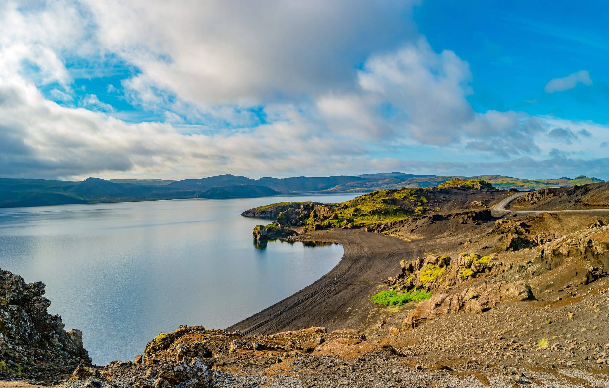 The black-sand shore of Lake Kleifarvatn stretches across the Reykjanes Peninsula in summer, Iceland.