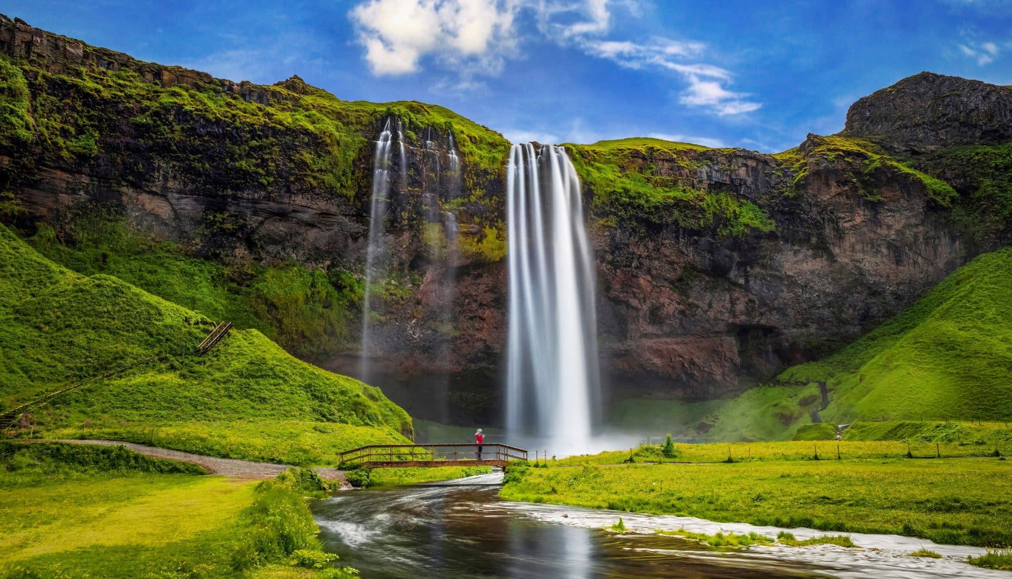 The Seljalandsfoss waterfall drops past green summer cliffs on the south coast of Iceland.