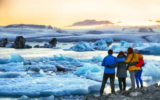 A group of travelers taking in the view of icebergs at Jokulsarlon Glacier Lagoon.
