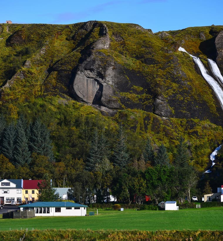 Kirkjubaejarklaustur village with waterfalls and green cliffs in South Iceland.