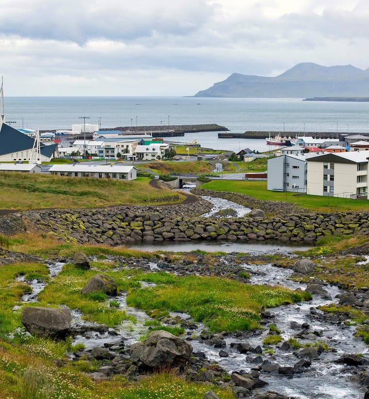 Olafsvik fishing village on Iceland's Snaefellsnes Peninsula with mountains and harbor in the background.