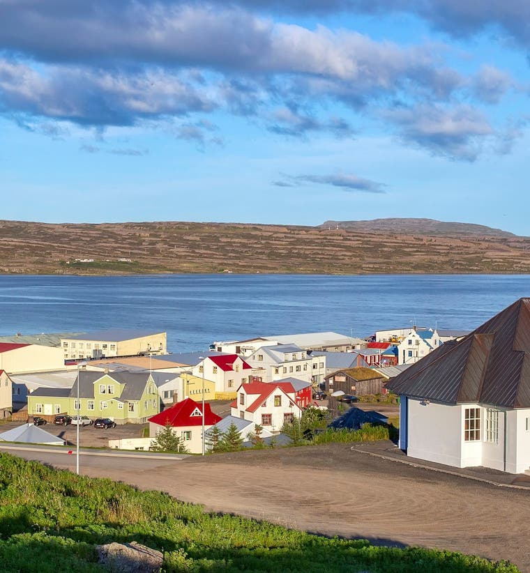 White church and colorful houses of Holmavik Village beside Steingrimsfjordur Fjord in the Icelandic Westfjords