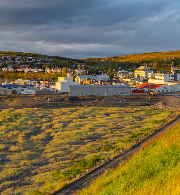 Husavik town in Northeast Iceland at sunset, near local cottages.