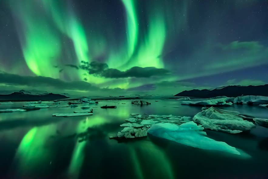 Northern lights above an ice formation on a black sand beach in Iceland
