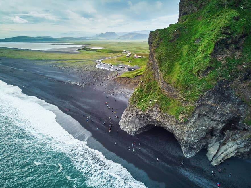 Car park at Reynisfjara Black Sand Beach with parked vehicles and visitors