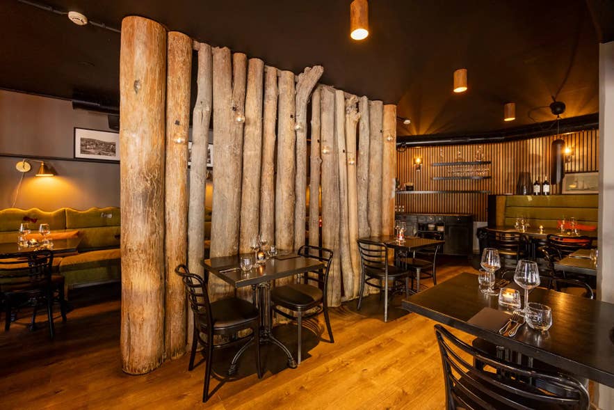 Driftwood columns from Hedinsfjordur divide the dining tables at Sjávargrillið in Reykjavik.