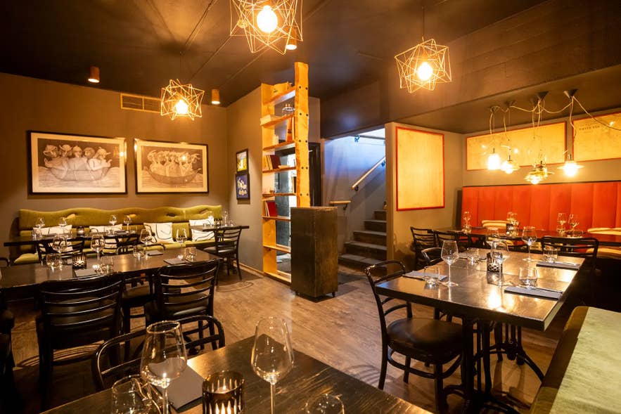 Upstairs dining room at Sjávargrillið with black-and-white photographs and pendant lights