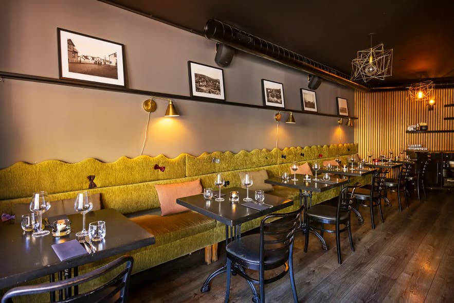 Long banquette seating and set tables at Sjávargrillið restaurant in Reykjavik