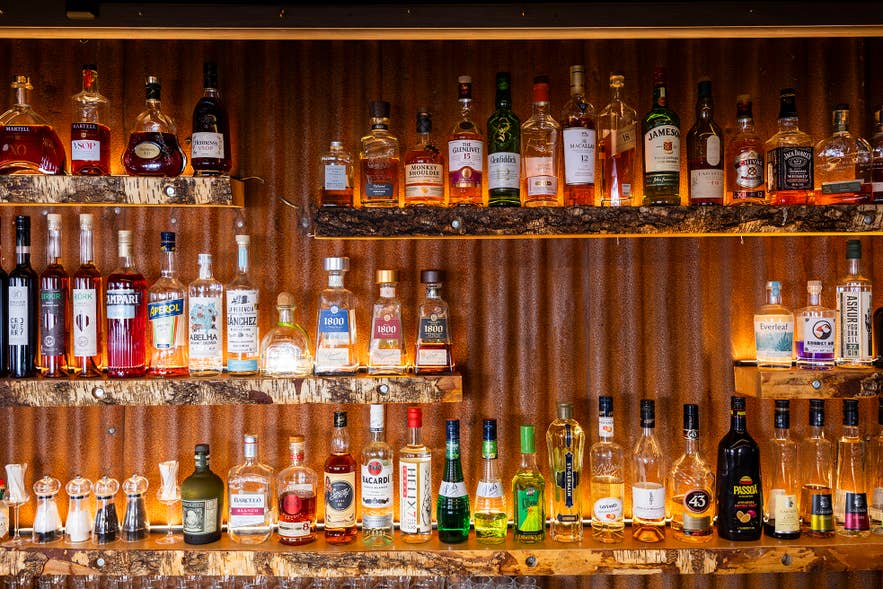 Shelves of spirits against the corrugated iron wall behind the bar at Sjávargrillið.
