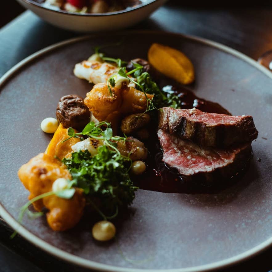 Grilled meat main with roasted vegetables and red wine sauce at Sjávargrillið.