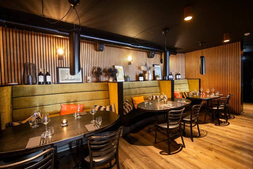 Olive-green banquettes and black tables in the ground-floor dining room at Sjavargrillid in Reykjavik.