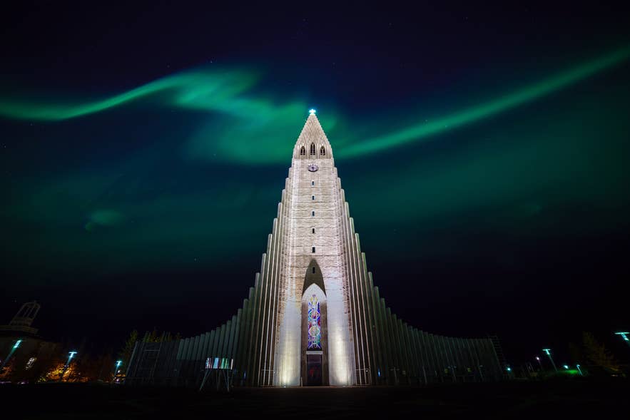 Green northern lights sweep across the night sky above Hallgrimskirkja Church in central Reykjavik.