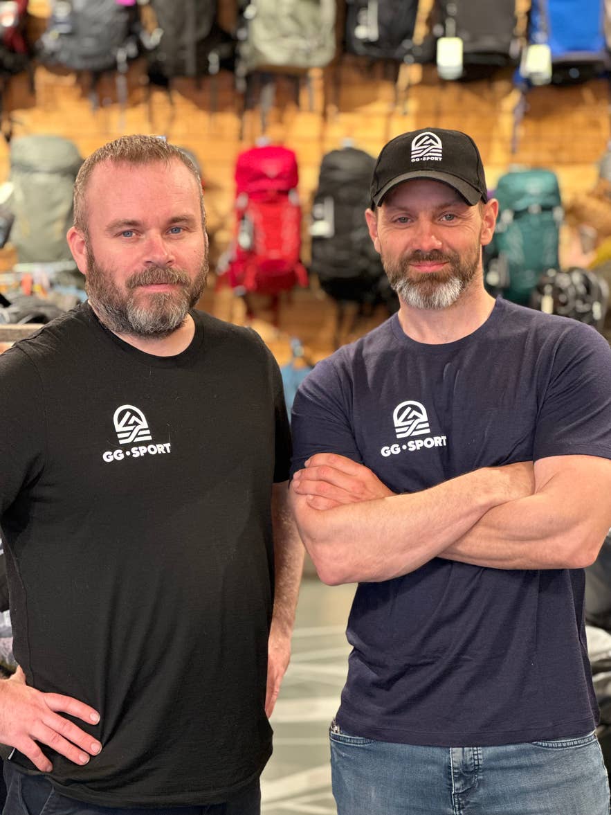 Founders of GG Sport in Iceland standing in front of a wall of backpacks.