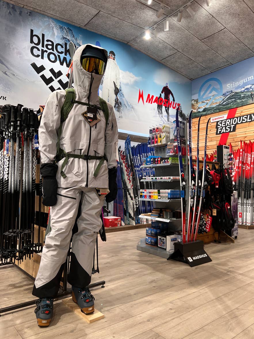 Mannequin wearing white ski gear beside skis and winter equipment in GG Sport in Iceland.