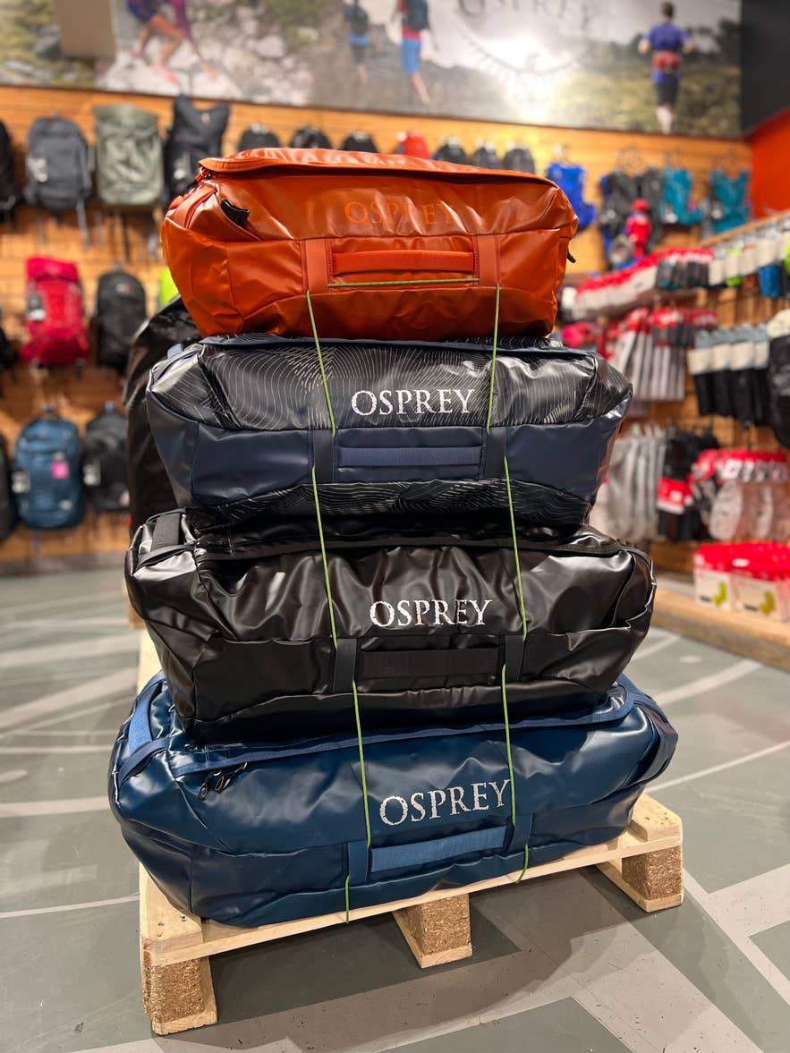 Stack of Osprey duffel bags displayed inside GG Sport, outdoor equipment shop in Iceland.