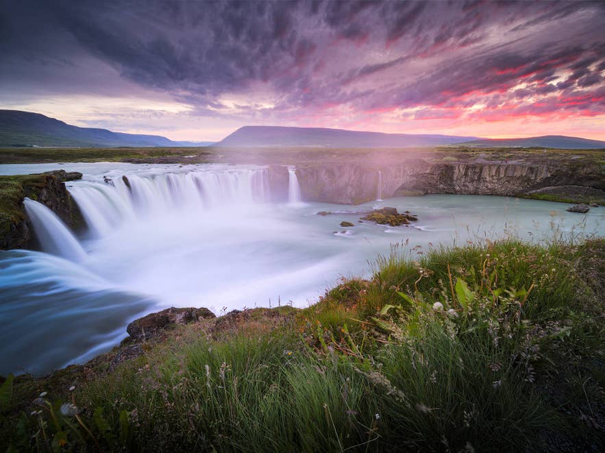 Godafoss waterfall in North Iceland under a pink sunset sky