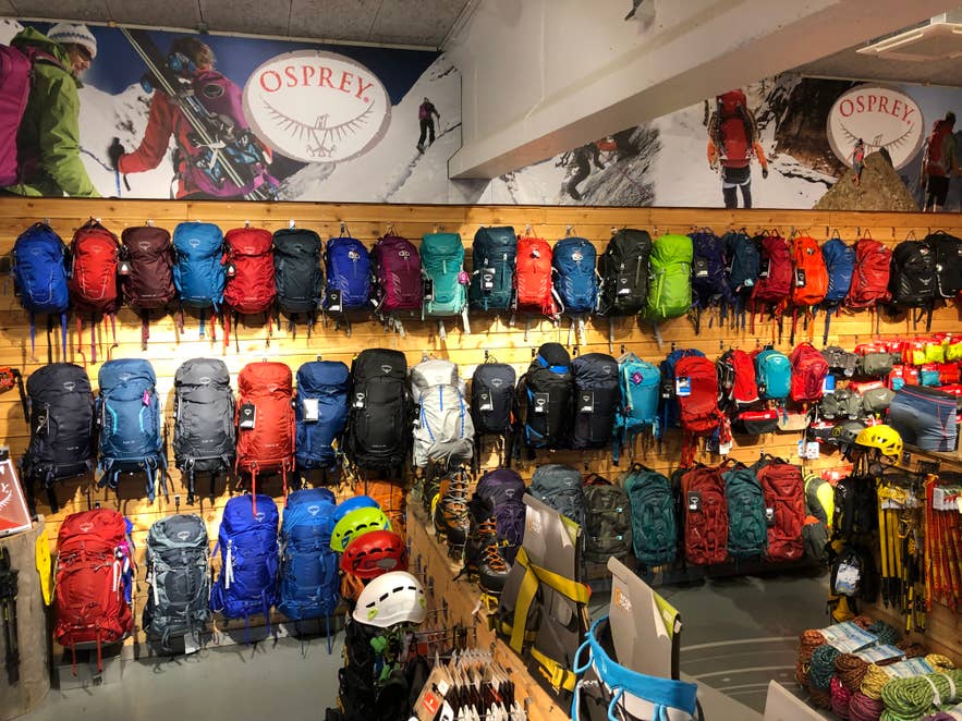 Backpacks displayed on a wooden wall inside GG Sport, an outdoor gear shop in Iceland.