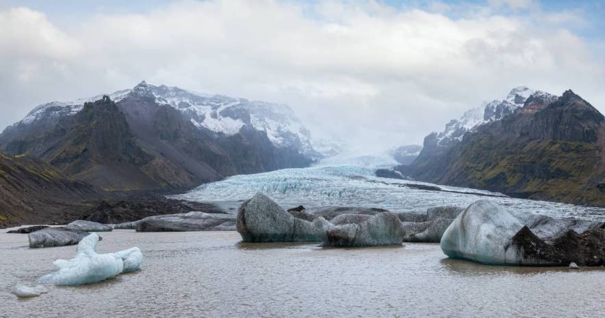 Icebergs floating in a glacier lagoon below a glacier snout in Iceland