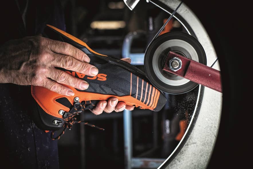 Outdoor technician repairing a hiking boot at Fjallakofinn's on-site workshop.