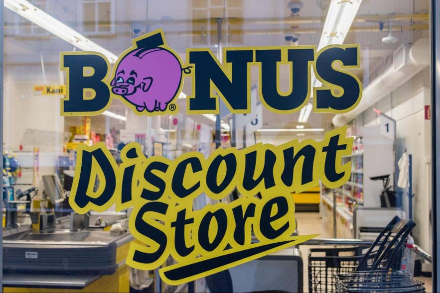 The Bonus discount store sign with its pink pig logo on a shop window in Iceland. The Bonus discount store sign with its pink pig logo on a shop window in Iceland.