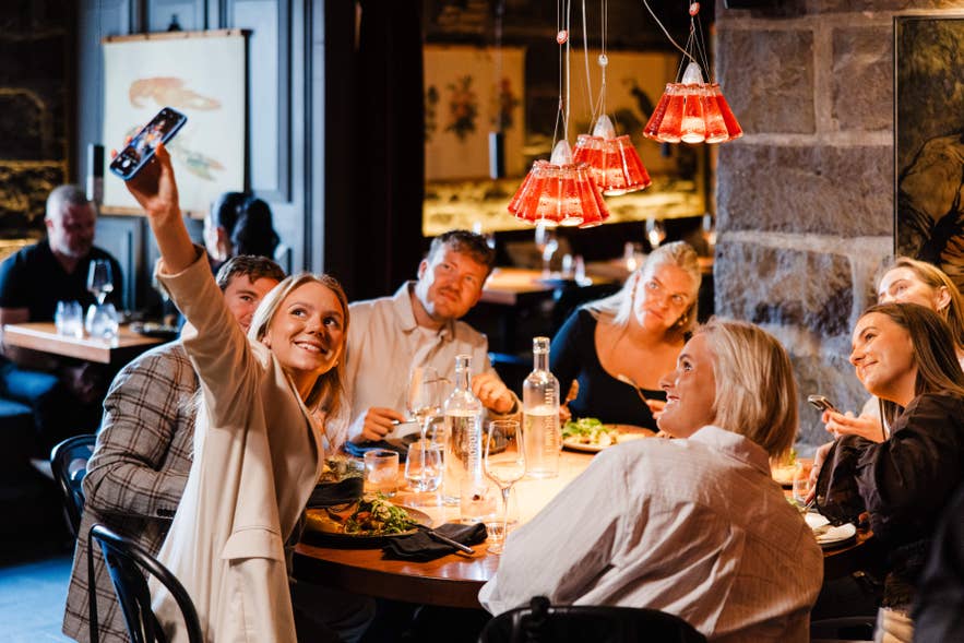 Group of diners taking a selfie around a table at Matarkjallarinn in Reykjavik