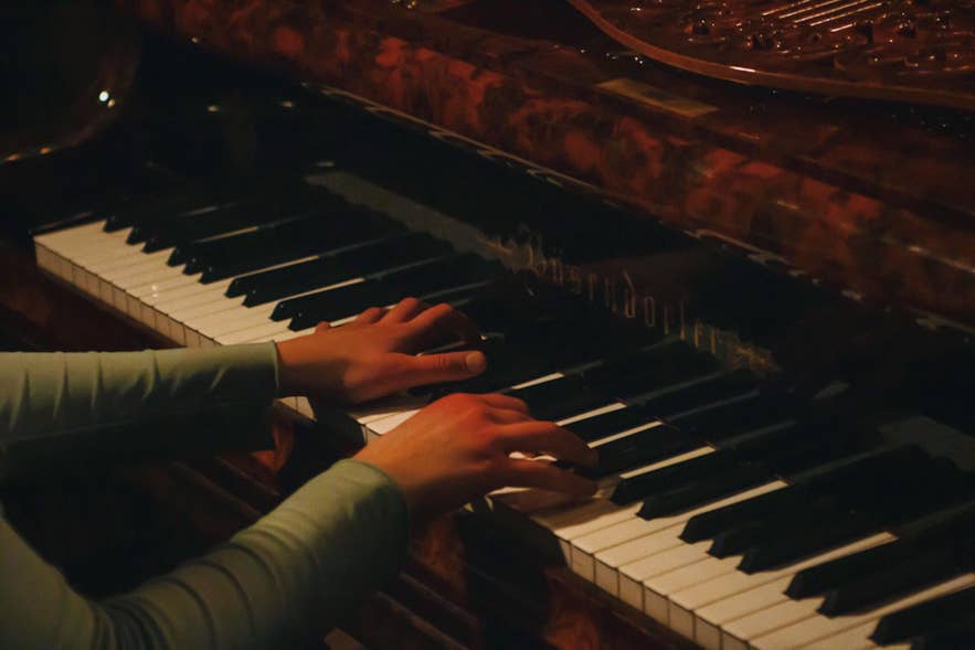 Pianist playing the grand piano during dinner service at Matarkjallarinn in Reykjavik