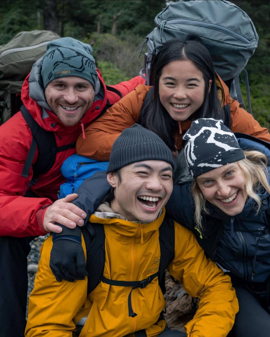 A group of hikers wearing Arc'teryx gear smiling together on a hiking trip.
