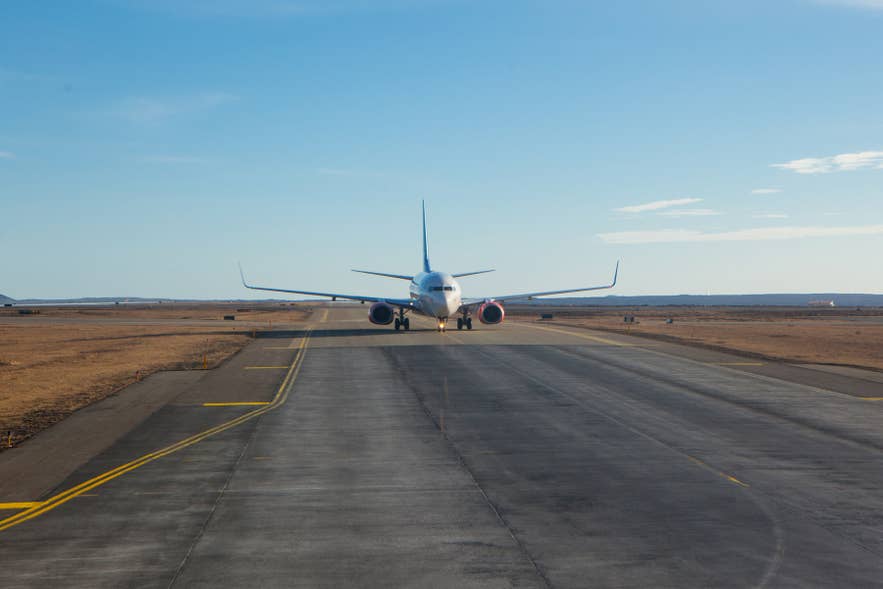 Passenger jet taxis along a runway at Keflavik International Airport on a clear day in Iceland. Passenger jet taxis along a runway at Keflavik International Airport on a clear day in Iceland.