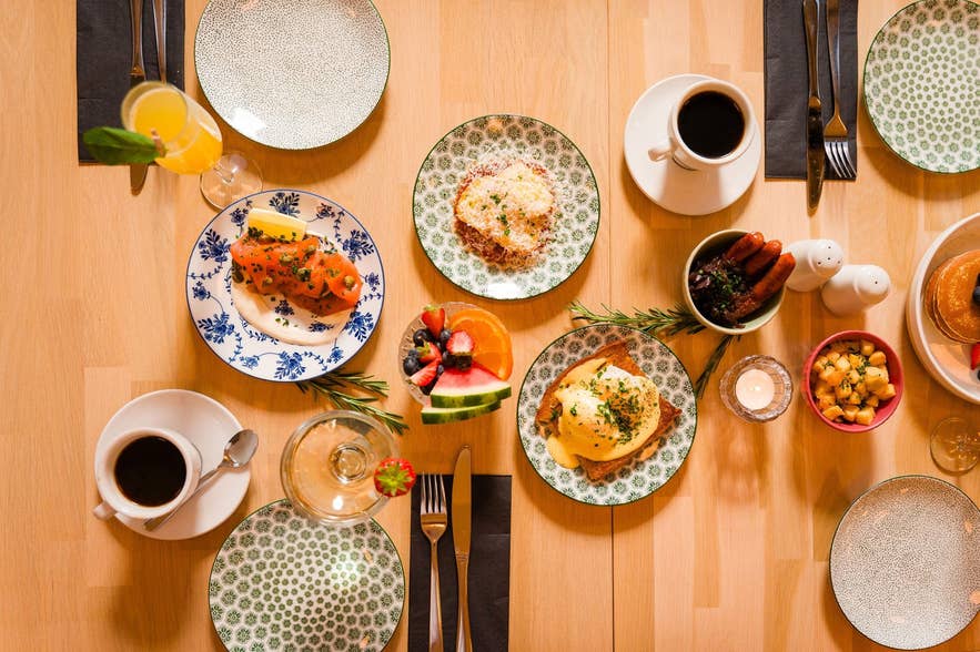 Brunch med ägg, pannkakor, frukt och kaffe på mönstrade tallrikar på Terian Brasserie i Akureyri