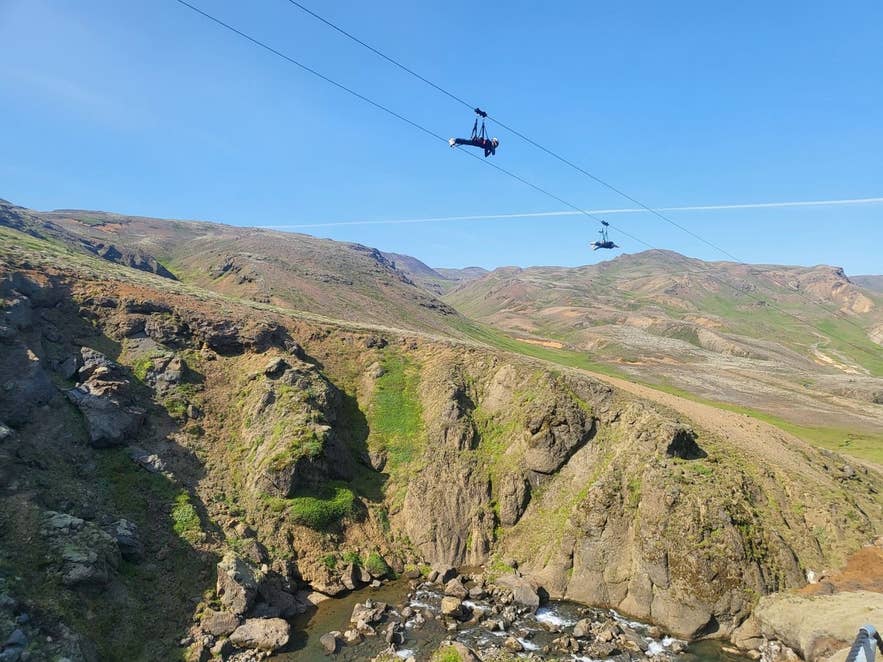 Mega Zipline riders crossing Svartagljúfur gorge above the Hengladalsá river near Hveragerði