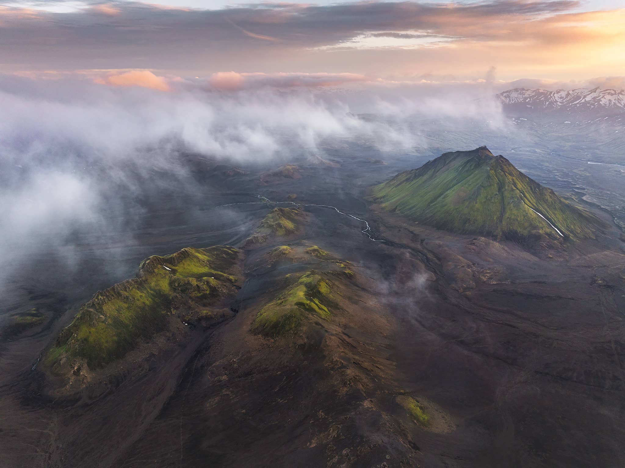 Low clouds drift over moss-covered mountains near the Laugavegur Trail in the Highlands of Iceland.