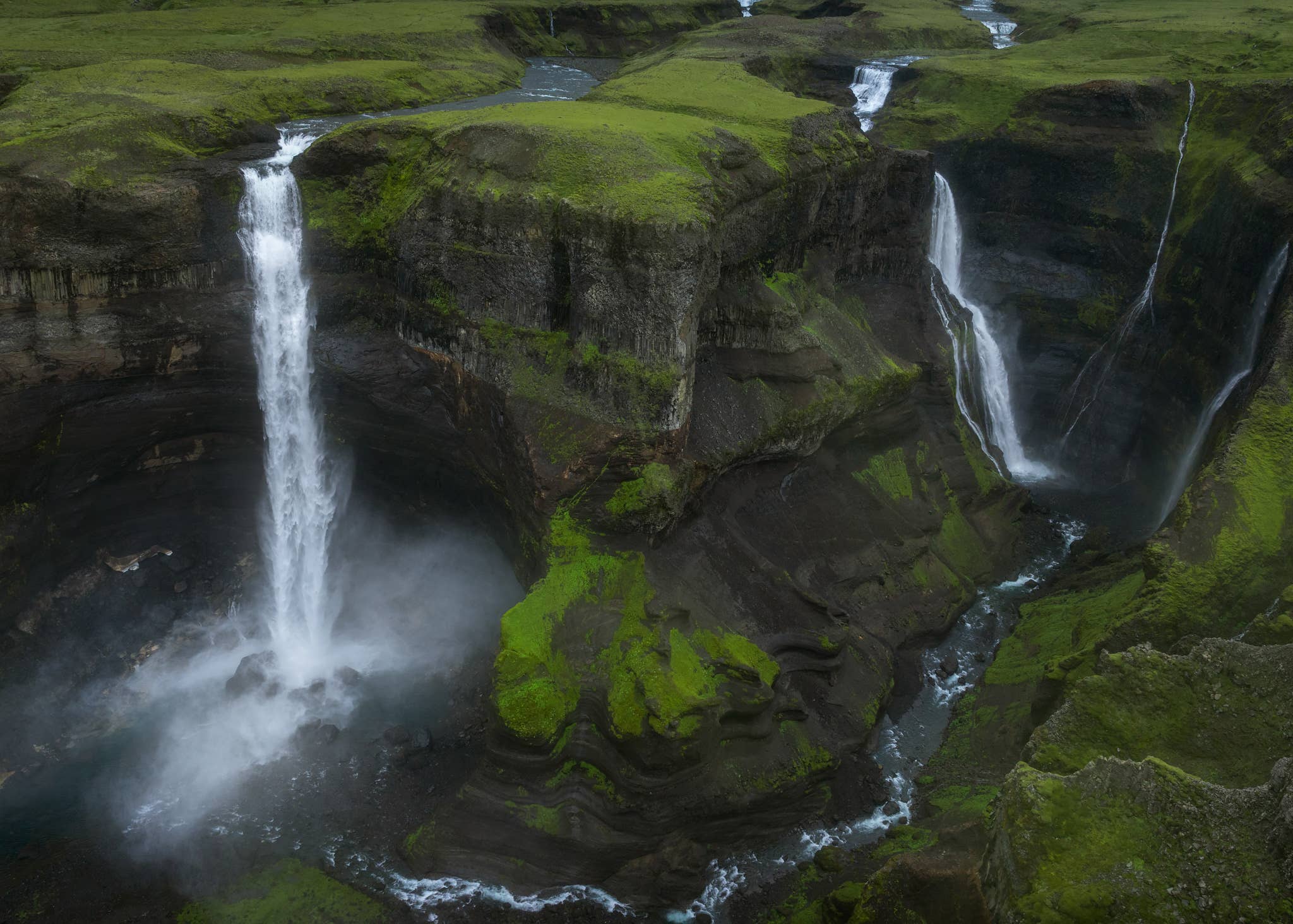 Haifoss Waterfall and Granni Waterfall plunge into a moss-covered canyon in the Highlands of Iceland.