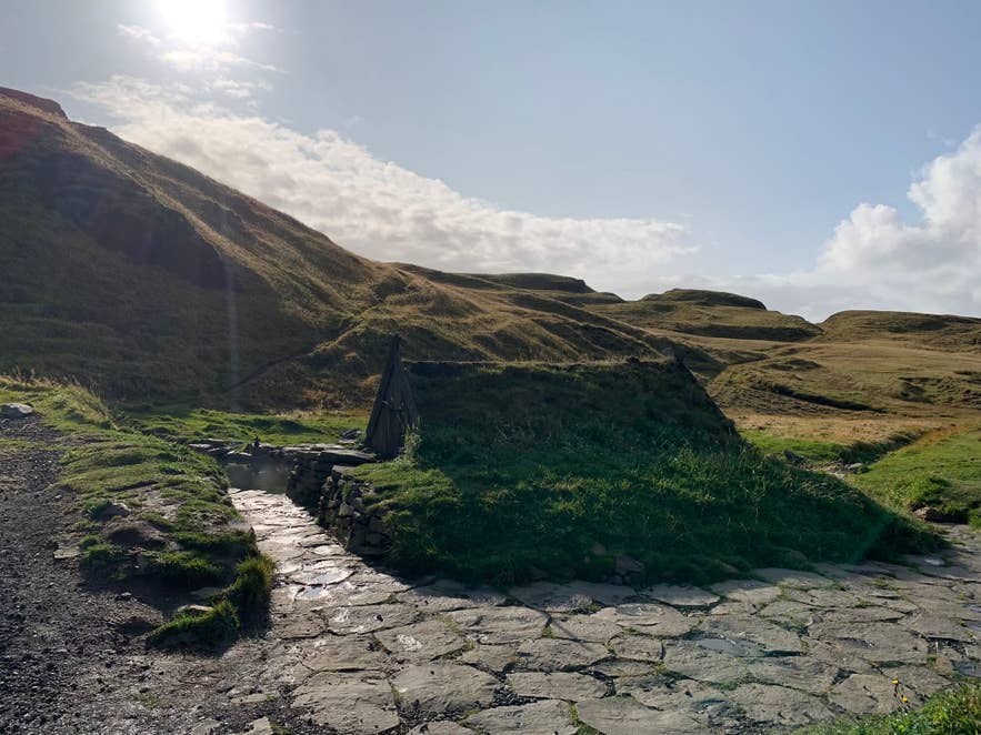 Stone path leading to the turf-roofed hut at Hrunalaug Hot Spring